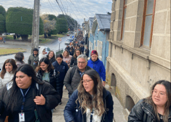 Gran grupo de personas caminando por una calle.