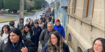 Gran grupo de personas caminando por una calle.