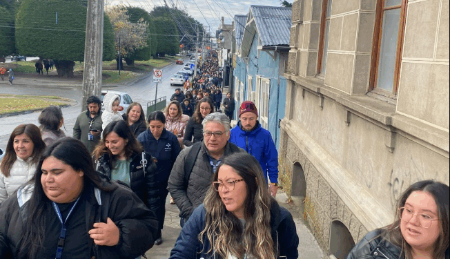 Gran grupo de personas caminando por una calle.