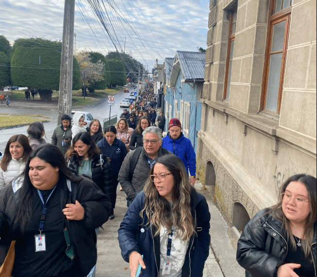 Gran grupo de personas caminando por una calle.