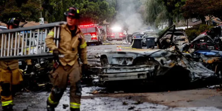 Los bomberos trabajan en el sitio donde un pequeño avión se estrelló contra un San Diego, California, el 22 de mayo de 2025. (Sandy Huffaker/AFP a través de Getty Images)