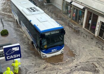 Autobús sumergido en aguas de inundación.