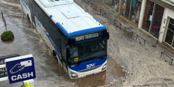 Autobús sumergido en aguas de inundación.