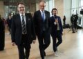 Friedrich Merz, canciller alemán designado, con otros dos hombres, uno de los cuales sostiene un micrófono.