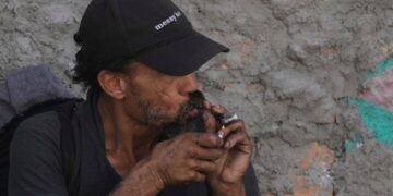 Persona fumando crack cocaína.