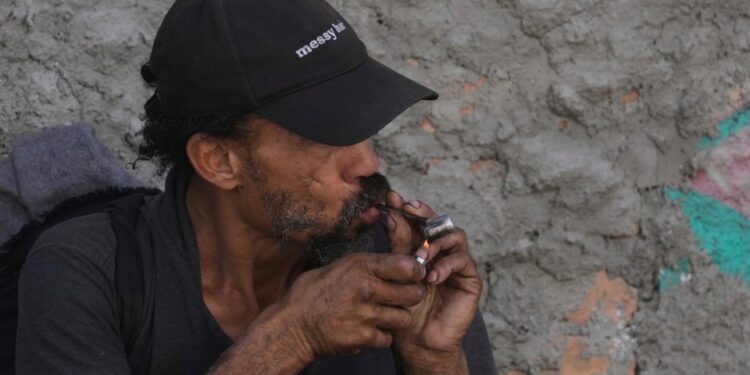 Persona fumando crack cocaína.