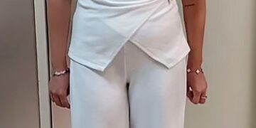 Charlotte May Lee en un traje de pantalón blanco.