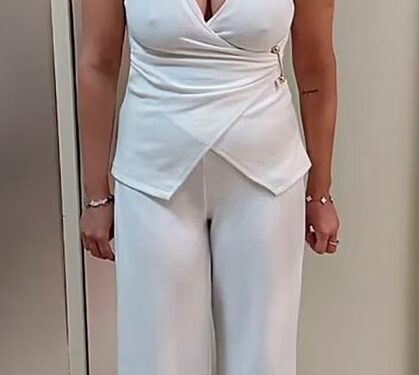 Charlotte May Lee en un traje de pantalón blanco.