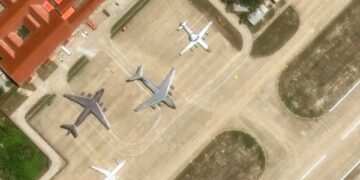 Vista aérea de múltiples aviones estacionados en una pista.