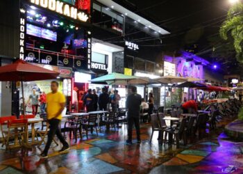 Escena nocturna en Medellin, Colombia, que muestra a los turistas en cafés al aire libre y bares de narguile.