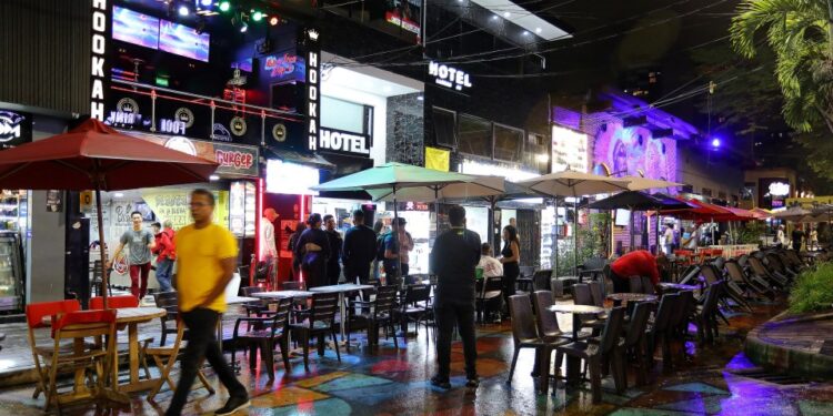 Escena nocturna en Medellin, Colombia, que muestra a los turistas en cafés al aire libre y bares de narguile.
