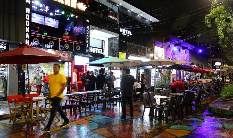 Escena nocturna en Medellin, Colombia, que muestra a los turistas en cafés al aire libre y bares de narguile.