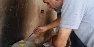 Hamdi Hammoda prepara la sopa de lentejas el 11 de mayo de 2025. Las lentejas son ahora la única comida que queda en su casa en el barrio de Gaza de Tal Al-Hawa.