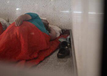 Hombre sin hogar durmiendo en el piso del aeropuerto de Palma.