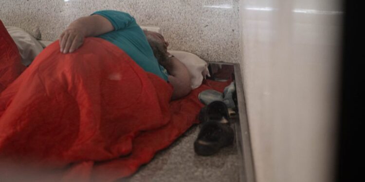 Hombre sin hogar durmiendo en el piso del aeropuerto de Palma.