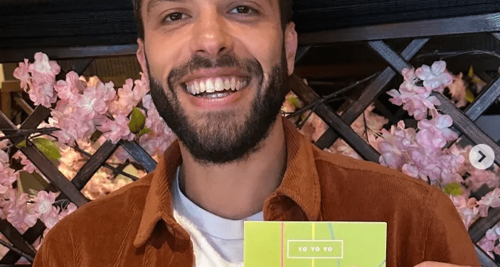 Hombre sosteniendo una tarjeta temática de yo-yo.