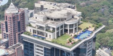 Vista aérea de una mansión sobre un rascacielos.