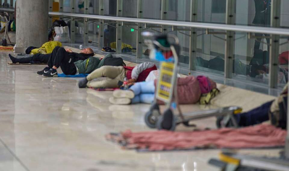 Gente que duerme en el piso de una terminal del aeropuerto.