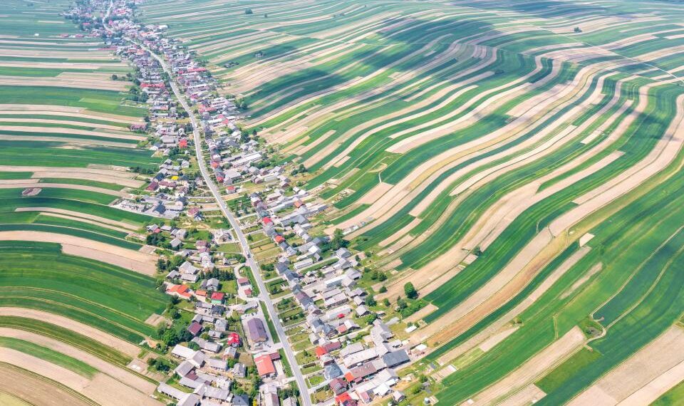 Vista aérea de la aldea de Sloszowa en Polonia, rodeada de campos agrícolas.