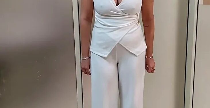 Mujer con traje de pantalón blanco.
