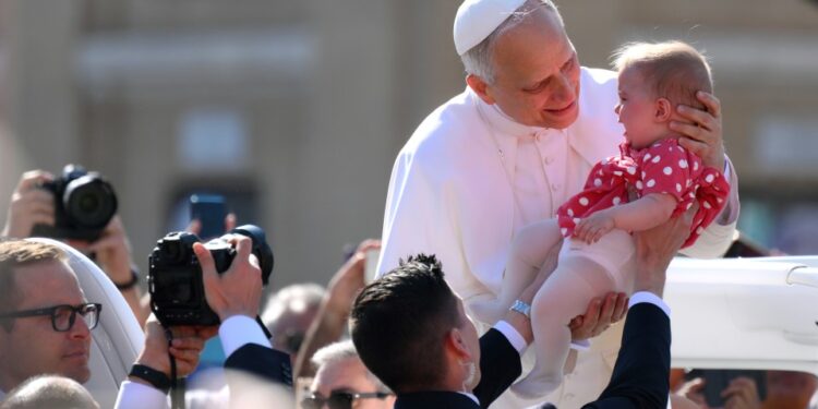 Papa Leo XIV sosteniendo un bebé.