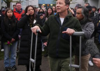 El hombre de las muletas habla a una vigilia.