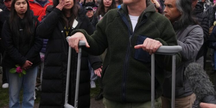 El hombre de las muletas habla a una vigilia.
