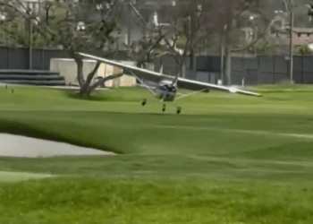 Pequeño avión que aterriza en un campo de golf.