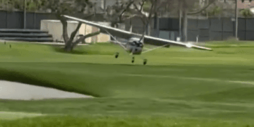 Pequeño avión que aterriza en un campo de golf.