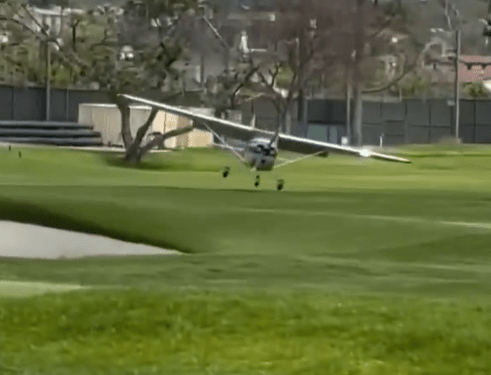 Pequeño avión que aterriza en un campo de golf.