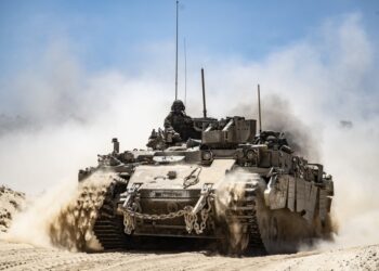 Tanque del ejército israelí que se mueve a lo largo de la frontera, pateando polvo.