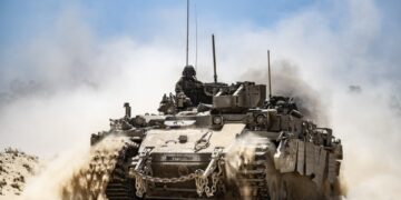 Tanque del ejército israelí que se mueve a lo largo de la frontera, pateando polvo.