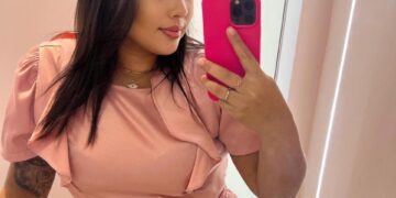 Mujer tomando una selfie con un atuendo rosa.