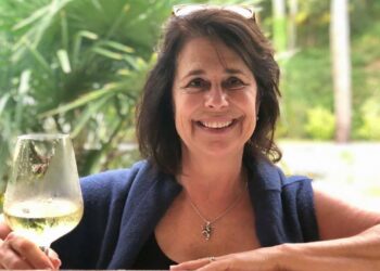 Mujer sosteniendo una copa de vino blanco.