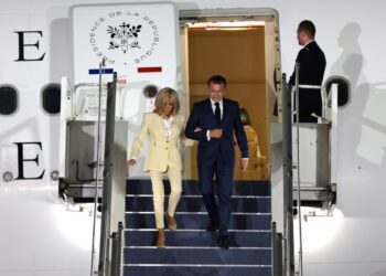 Emmanuel y Brigitte Macron desembarcando desde un avión.