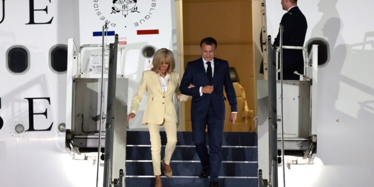 Emmanuel y Brigitte Macron desembarcando desde un avión.