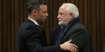 Oscar Pistorius abrazando a su padre en la corte.