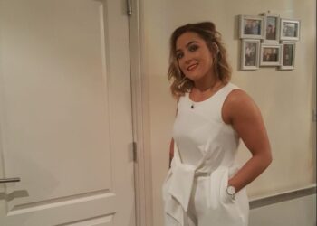 Mujer con mono blanco y tacones de oro.