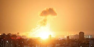 Explosión de misiles balísticos sobre una ciudad por la noche.