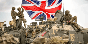 Soldados británicos con un Jack Union en un vehículo militar.