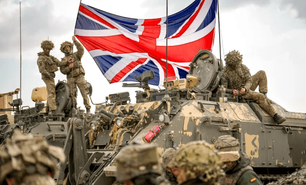 Soldados británicos con un Jack Union en un vehículo militar.