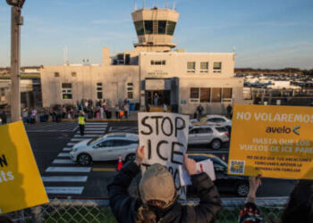 Los manifestantes marchan frente al aeropuerto de Tweed, dejando carteles colgando a lo largo de la cerca que critican a Avelo Airlines por sus planes para ayudar al Departamento de Seguridad Nacional a deportar a los migrantes de Mesa, Arizona, de los Estados Unidos, en New Haven, Connecticut, el 17 de abril de 2025.