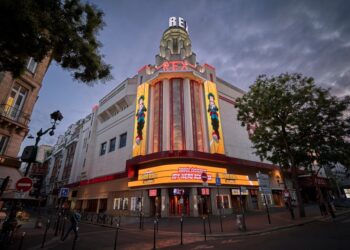 El cine Grand Rex en París al anochecer, que muestra un cartel de películas de My Hero Academia.