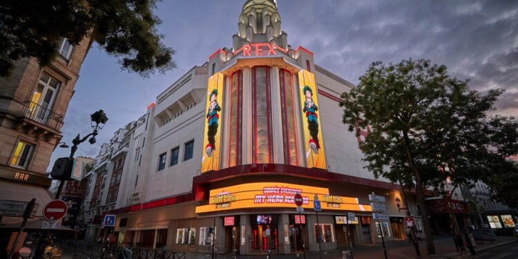 El cine Grand Rex en París al anochecer, que muestra un cartel de películas de My Hero Academia.