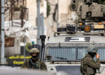 Los soldados del ejército israelí se paran afuera de un vehículo blindado durante una operación militar israelí en Nablus en Cisjordania ocupada el 8 de abril de 2025.