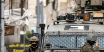 Los soldados del ejército israelí se paran afuera de un vehículo blindado durante una operación militar israelí en Nablus en Cisjordania ocupada el 8 de abril de 2025.