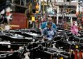 Los trabajadores colocan motores en el marco de los camiones F-150 con combustible Ford Motor Co. en su planta de camiones en Dearborn, Michigan, el 20 de septiembre de 2022. (Jeff Kowalsky/AFP a través de Getty Images)