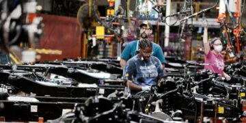 Los trabajadores colocan motores en el marco de los camiones F-150 con combustible Ford Motor Co. en su planta de camiones en Dearborn, Michigan, el 20 de septiembre de 2022. (Jeff Kowalsky/AFP a través de Getty Images)