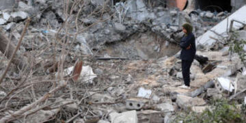 Una mujer se encuentra en medio de los escombros después de una huelga israelí en el Hospital Al-Ahli, también conocido como el Hospital Bautista o Árabe Ahli, en la ciudad de Gaza el 13 de abril de 2025.