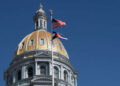 La bandera del estado de Estados Unidos y Colorado vuela frente al domo en la capital del estado de Colorado en Denver, Colorado, el 25 de marzo de 2025.